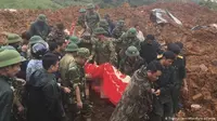Proses evakuasi korban tanah longsor yang menghantam sebuah barak militer di Vietnam. (AP Pictures)