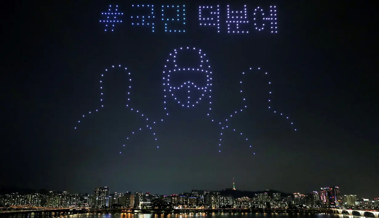 Dalam foto pada 4 Juli 2020 ini sekitar 400 drone terbang di atas Sungai Han menunjukkan pesan penghargaan untuk para pekerja medis selama pandemi virus corona di Seoul, Korea Selatan. Surat-surat itu berbunyi, “Terima kasih kepada orang-orang. ”(Lim Hwa-young/Yonhap via AP)