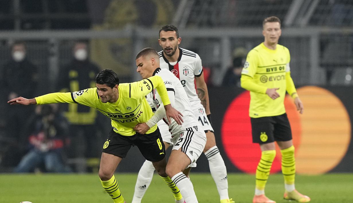 Pemain Borrusia Dortmund, Mahmoud Dahoud mengontrol bola dari kawalan pemain Besiktas. Can Bozdogan dalam pertandingan Grup C Liga Champions di Signal Iduna Park, Jerman, Rabu (8/12/2021). Dortmund menang telak atas Besiktas dengan skor 5-0. (AP Photo/ Martin Meissner)