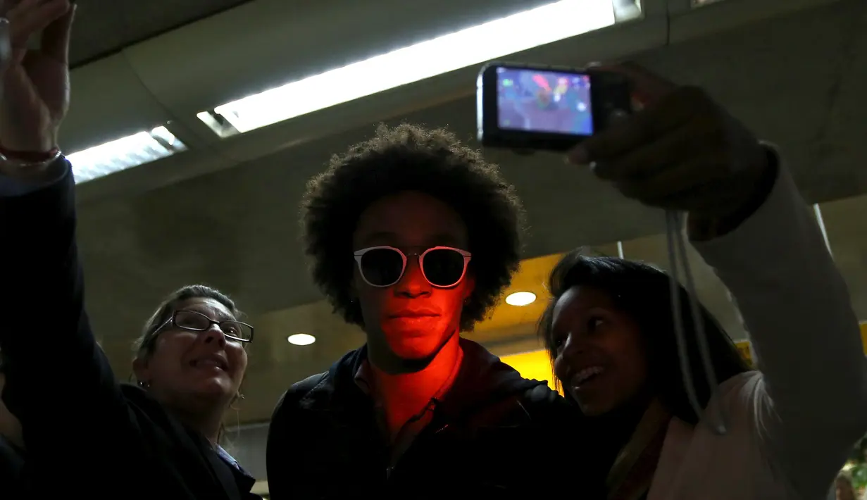 Gelandang Brasil, Willian berselfie bersama fans usai mengikuti turnamaen Copa Amerika 2015 di bandara Guarulhos International, Sao Paulo, Brasil, (28/6/2015). Brasil Kalah di perempat final melawan Paraguay dalam adu Penalti. (REUTERS/Paulo Whitaker)