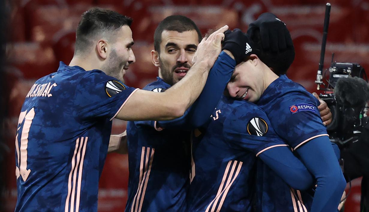 Gelandang Arsenal, Smith Rowe (kanan), melakukan selebrasi bersama rekan-rekannya usai mencetak gol ke-4 Arsenal ke gawang Rapid Wien dalam laga lanjutan Liga Europa 2020/21 Grup B di Emirates Stadium, Kamis (3/12/2020) waktu setempat. Arsenal mengalahkan Rapid Wien 4-1. (AFP/Adrian Dennis)