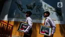 Dua murid Sekolah Dasar Negeri (SDN) Pondok Labu 14 membawa pigura foto Presiden Prabowo Subianto dan Wakil Presiden Gibran Rakabuming Raka, Jakarta, Selasa (22/10/2024). (Liputan6.com/Herman Zakharia)