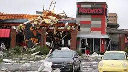 Seorang pria berdiri mengamati restoran yang ambruk akibat tornado di Tusla, Oklahoma, Minggu (6/8). Badai menyebabkan pemadaman listrik lebih dari 11.000 bangunan dan kerusakan di setiap sudut kota Tusla. (Tulsa World via AP/Tom Gilbert)