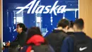Logo Alaska Airlines ditampilkan saat pelancong berdiri di area check-in Bandara Internasional Los Angeles (LAX) di Los Angeles, California, Senin (8/1/2024). (Mario Tama/Getty Images/AFP)