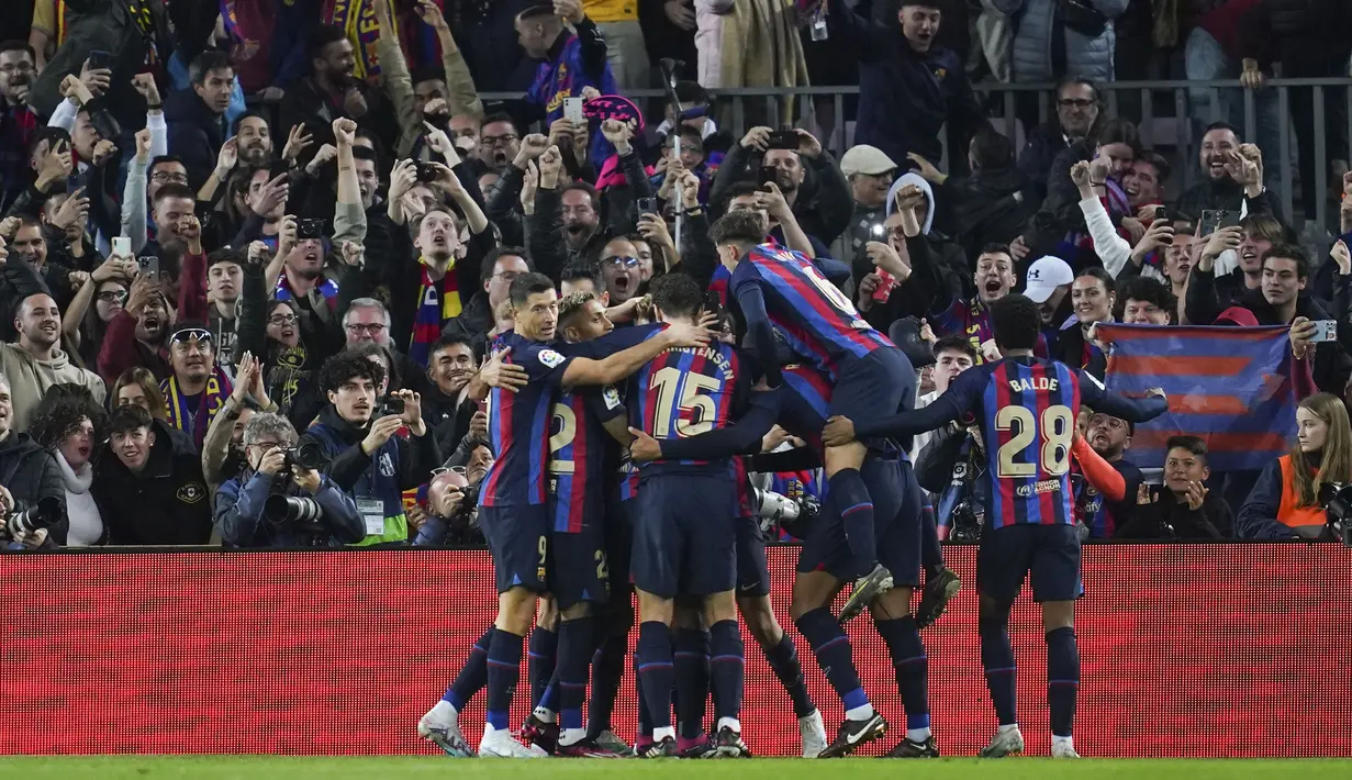 Sejumlah pemain Barcelona merayakan gol ke gawang Real Madrid pada laga pekan ke-26 Liga Spanyol 2022/2023 di Camp Nou, Barcelona, Senin (20/03/2023). Blaugrana menang dengan skor 2-1 pada pertandingan yang bertajuk El Classico tersebut. (AP Photo/Joan Mateu)