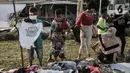 Anak-anak dan orangtua memilih pakaian saat kehadiran Perpustakaan Keliling di kawasan Kampung Melayu, Jakarta, Minggu (16/8/2020). Kegiatan sosial ini menghadirkan latihan tari, donasi pakaian layak, makanan, serta masker. (merdeka.com/Iqbal S. Nugroho)