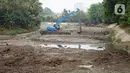 Petugas Sudin Sumber Daya Air (SDA) menggunakan alat berat untuk mengeruk lumpur yang mengendap di Setu Mangga Bolong, Jagakarsa, Jakarta, Rabu (2/9/2020). Pengerukan untuk meningkatkan fungsi setu sebagai tangkapan air, pengendali banjir dan penambahan daya tampung. (Liputan6.com/Immanuel Antonius)