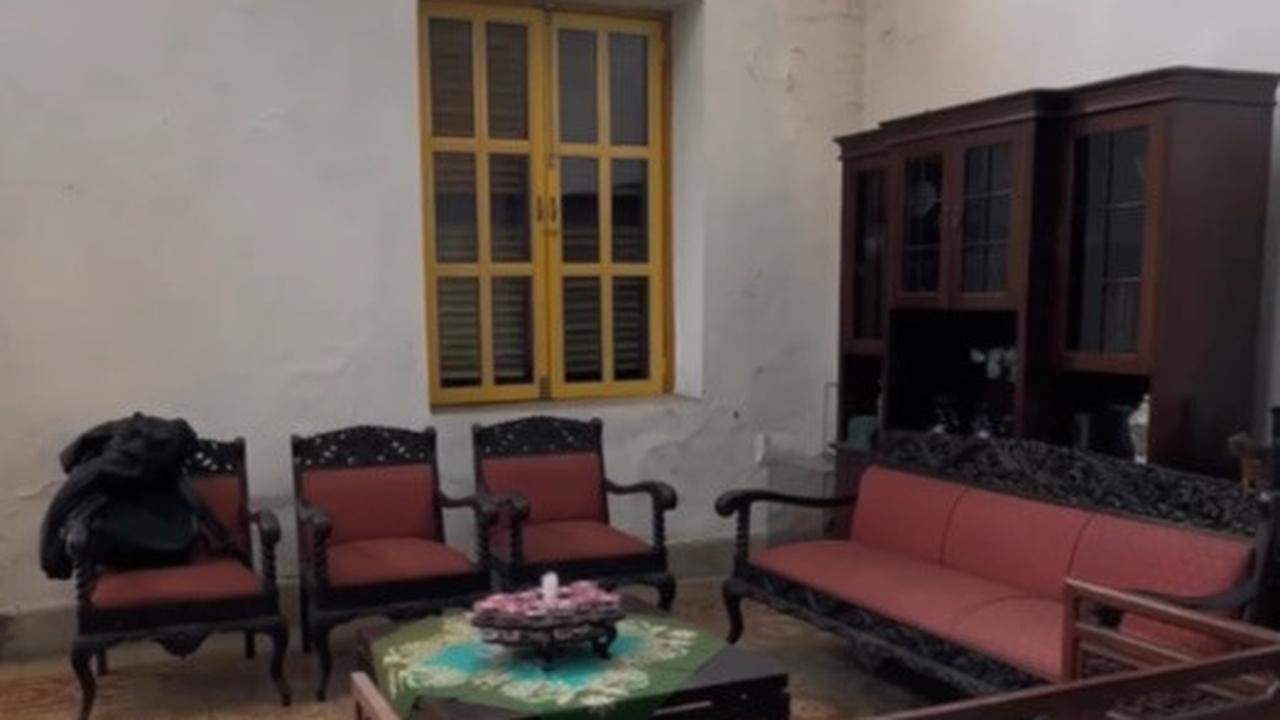 Masuk ke area dalam, tampak ada satu set kursi klasik tempo dulu yang masih utuh meski mulai memudar. Bagian lantai masih mempertahankan gaya lawas dengan ubin kuning bermotif.