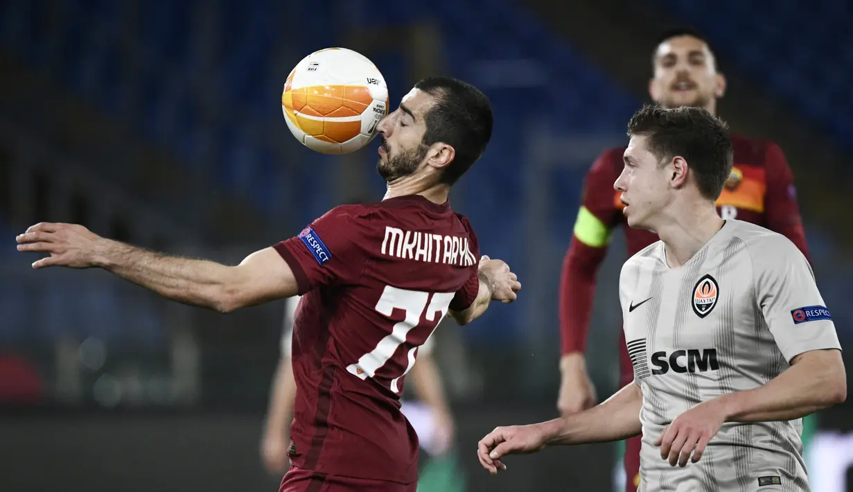 Gelandang AS Roma, Henrikh Mkhitaryan (kiri) mengontrol bola saat bertanding melawan Shakhtar Donetsk pada pertandingan leg pertama babak 16 besar Liga Europa di stadion Olimpiade, Italia, Jumat (12/3/2021). AS Roma menang telak atas Shakhtar Donetsk 3-0. (AFP/Filippo Monteforte)