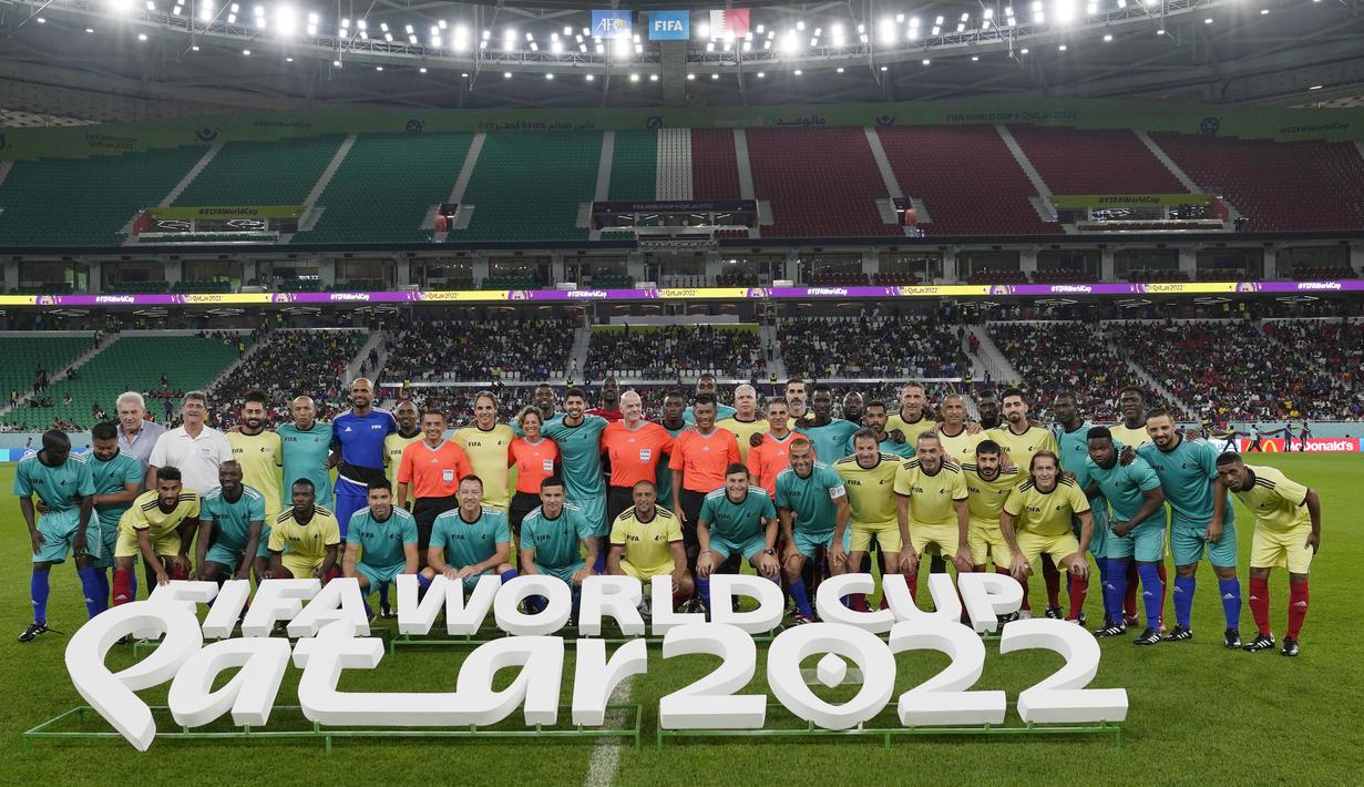 Sejumlah pesepak bola legendaris foto bersama staf FIFA pada laga hiburan jelang semi final Piala Dunia di Stadion Al Thumama, Senin (12/12/2022). (AP Photo/Frank Augstein)