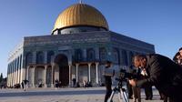 Seorang pria menggunakan teleskop saat mencari bulan sabit untuk menandai dimulainya bulan suci Ramadan di kompleks Masjid Al-Aqsa, Yerusalem, pada 28 Februari 2025. (Dok. AFP)