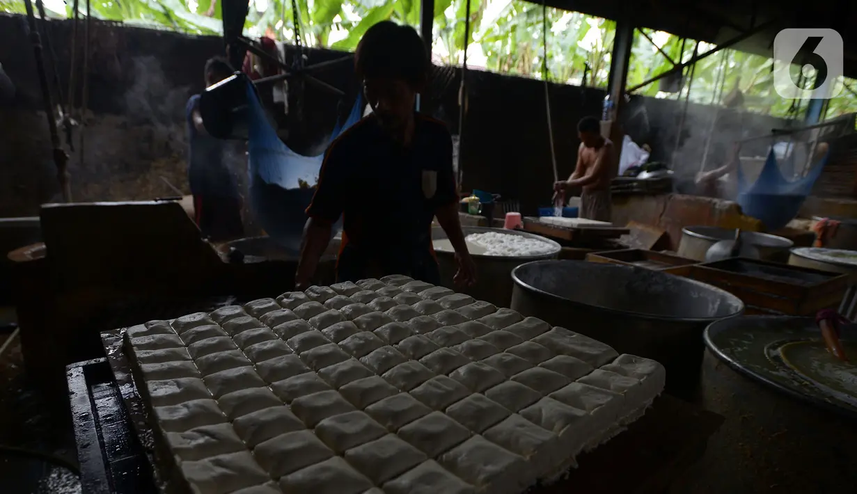 Pekerja mencetak tahu saat proses produksi di industri rumahan, kawasan Duren Tiga, Jakarta, Selasa (15/9/2020). Pemerintah telah menggelontorkan anggaran sebesar Rp 692,2 triliun untuk program Pemulihan Ekonomi Nasional (PEN). (merdeka.com/Imam Buhori)