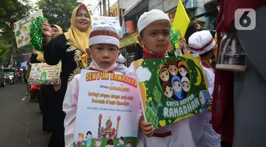 Sejumlah murid TK Islam berjalan bersama sambil membawa poster di Jalan Raya Radjiman Widyo Ningrat, Jakarta, Sabtu (26/3/2022). Pawai menyambut datangnya bulan suci Ramadan 1443 Hijriah ini diikuti puluhan murid TK Islam dari berbagai sekolah. (merdeka.com/Imam Buhori)