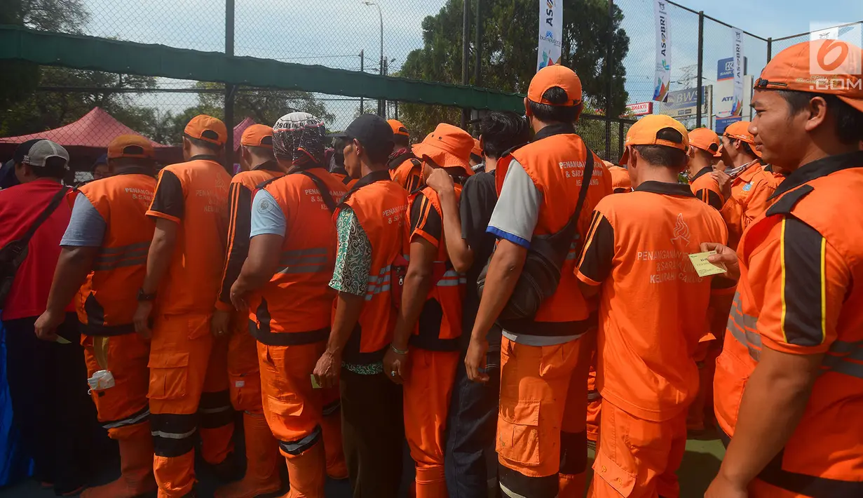 Petugas Penangganan Prasarana dan Saran Umum (PSSU) atau pasukan oranye mengantre sembako gratis di Jakarta, Jumat (3/8). Pembagian sembako gratis tersebut dalam rangka menyambut HUT ASABRI ke-47 tahun. (Merdeka.com/Imam Buhori)