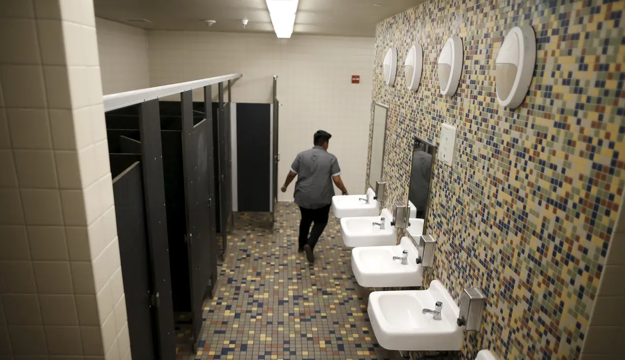 Seorang siwa berjalan keluar dari toilet netral gender pertama di Santee High School, Los Angeles, California, AS, Senin (18/4). Toilet disediakan sebagai langkah mendukung dan menampung siswa transgender. (REUTERS/Lucy Nicholson)