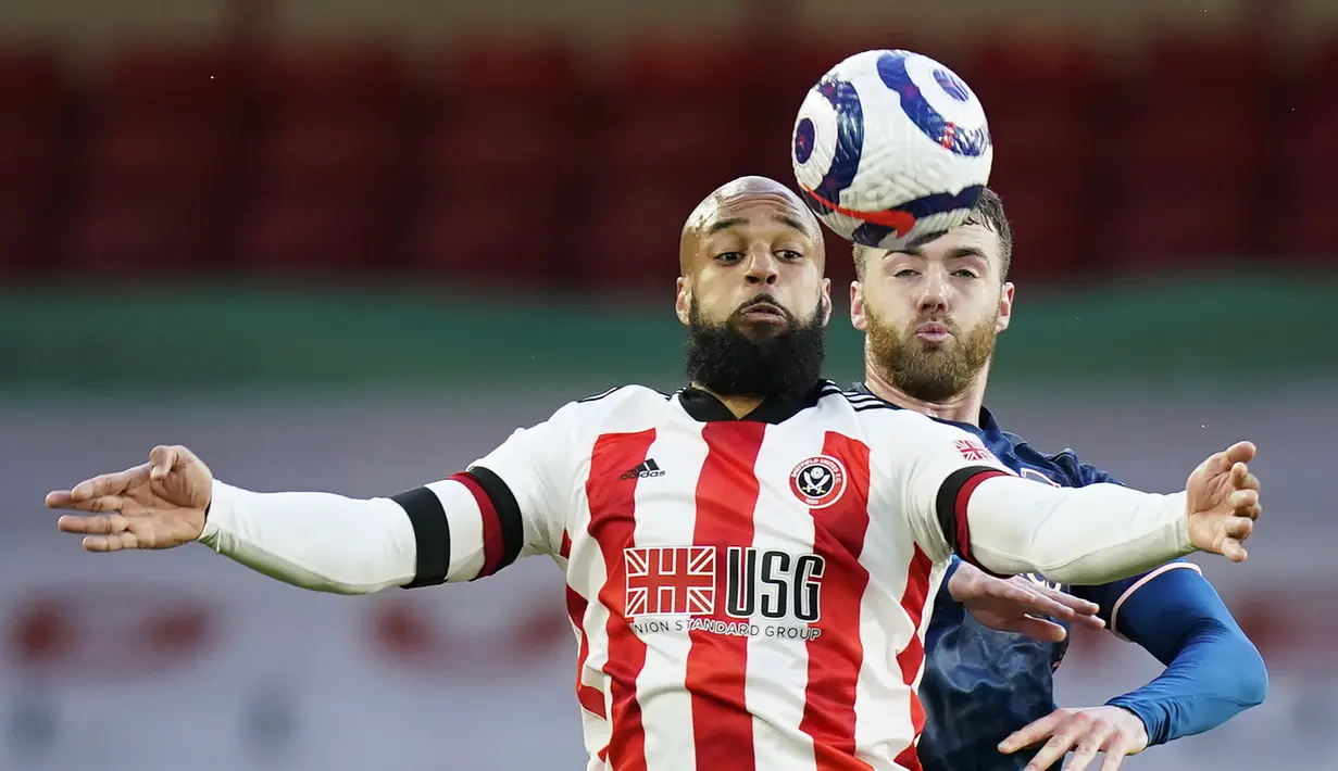 Penyerang Sheffield United, David McGoldrick mengontrol bola dari kawalan bek Arsenal, Calum Chambers pada pertandingan lanjutan Liga Inggris di stadion Bramall Lane di Sheffield, Inggris, Senin (12/4/2021). Arsenal menang telak atas Sheffield United 3-0. (AP Photo/Tim Keeton, Pool)