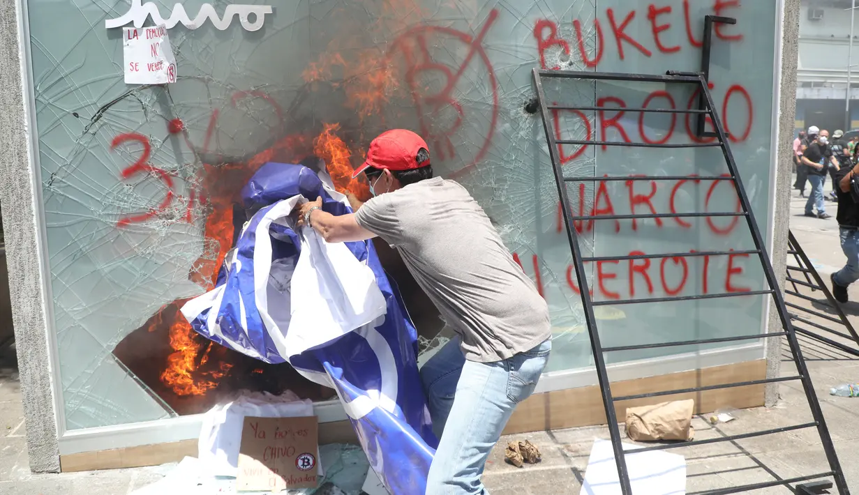 Seorang demonstran merusak ATM Bitcoin bernama Chivo selama protes terhadap kebijakan Presiden Nayib Bukele pada Hari Kemerdekaan di San Salvador, El Salvador, Rabu (15/9/2021). Massa juga memprotes Bukele yang dikhawatirkan kembali mengikuti pemilihan pada tahun 2024 mendatang. (MARVIN RECINOS/AFP)