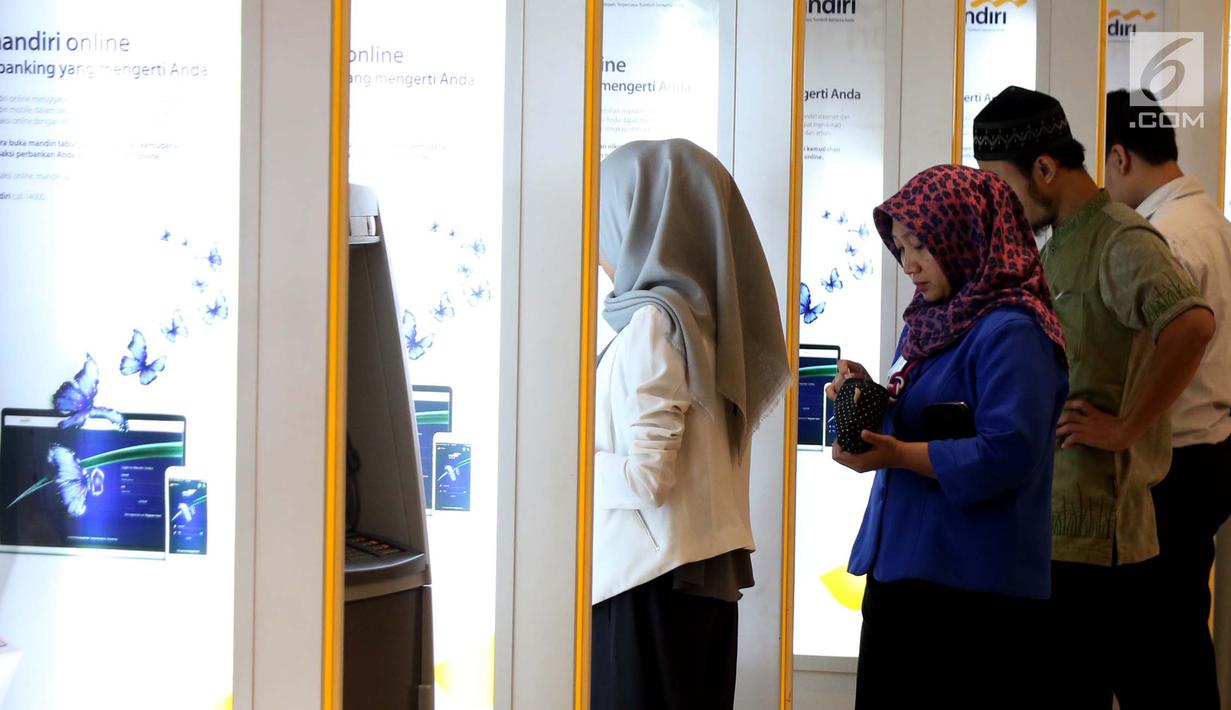 Sejumlah nasabah melakukan transaksi di ATM Mandiri, Jakarta, Selasa (6/6). Jumlah tersebut meningkat sekitar 10 persen dibandingkan kebutuhan uang tunai harian pada bulan-bulan biasanya. (Liputan6.com/Angga Yuniar)