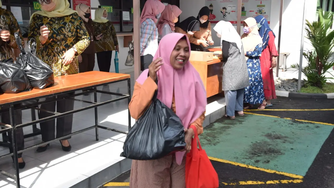 Seorang warga nampak bungah mendapatkan paket bazar sembako murah Adhiyaksa Garut seharga Rp 100 ribu per paket.