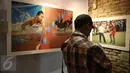 Pengunjung memperhatikan karya foto pada pameran foto Anugerah Pewarta Foto Indonesia (APFI) ke-VI di Gedung De Vries, Bandung, Sabtu (9/4). APFI 2016 memamerkan 25 foto tunggal dan tiga foto seri terbaik sepanjang  2015. (Liputan6.com/Faizal Fanani)