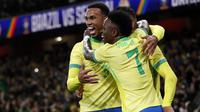 Gelandang Brasil #05, Casemiro (tengah), dikerumuni oleh bek Brasil #03, Gabriel Magalhaes (kiri), dan gelandang Brasil #07, Vinicius Jr, setelah mencetak gol kedua dalam pertandingan persahabatan internasional antara Brasil dan Senegal di Stadion Emirates, London, pada 15 November 2025. (Ian Kington/AFP)