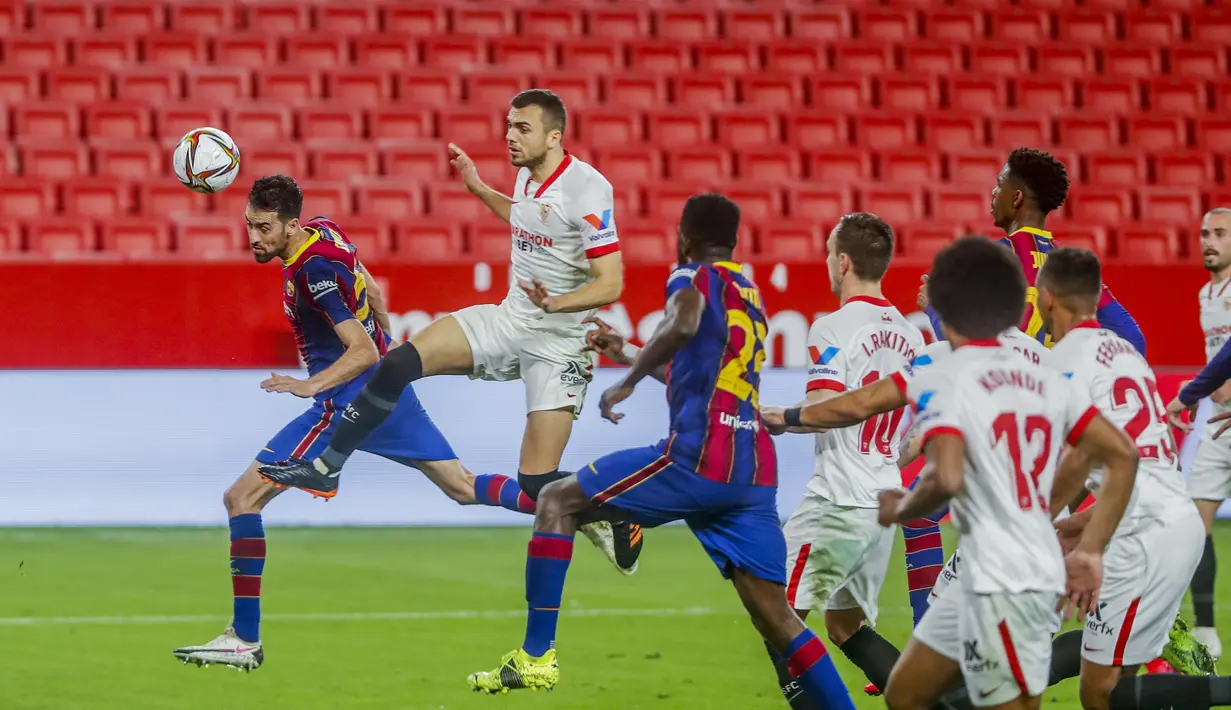 Gelandang Barcelona, Sergio Busquets berusaha menyundul bola saat bertanding melawan Barcelona pada pertandingan leg pertama semifinal Copa del Rey di stadion Ramon Sanchez Pizjuan, Spanyol, Kamis (10/2/2021).  Sevilla menang atas Barcelona 2-0. (AP Photo/Angel Fernandez)