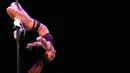 Kelenturan tubuh Little Snipper memperlihatkan gerakan saat Kompetisi Divison Profesional selama Kejuaraan Pole Dance (USPDF) AS 2019 di New York, 13 April 2019. Pole Dance merupakan seni pertunjukan gabungan tari dan akrobat yang menggunakan tiang. (TIMOTI A. CLARY / AFP)
