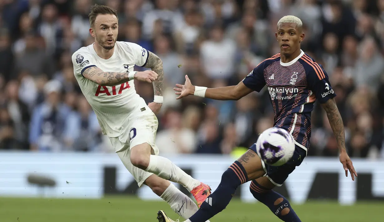 Gelandang Tottenham Hotspur, James Maddison (kiri) melepaskan tendangan di depan gelandang Nottingham Forest, Danilo pada laga pekan ke-32 Premier League 2023/2024 di Tottenham Hotspur Stadium, London, Minggu (7/4/2024) malam. (AP Photo/Ian Walton)