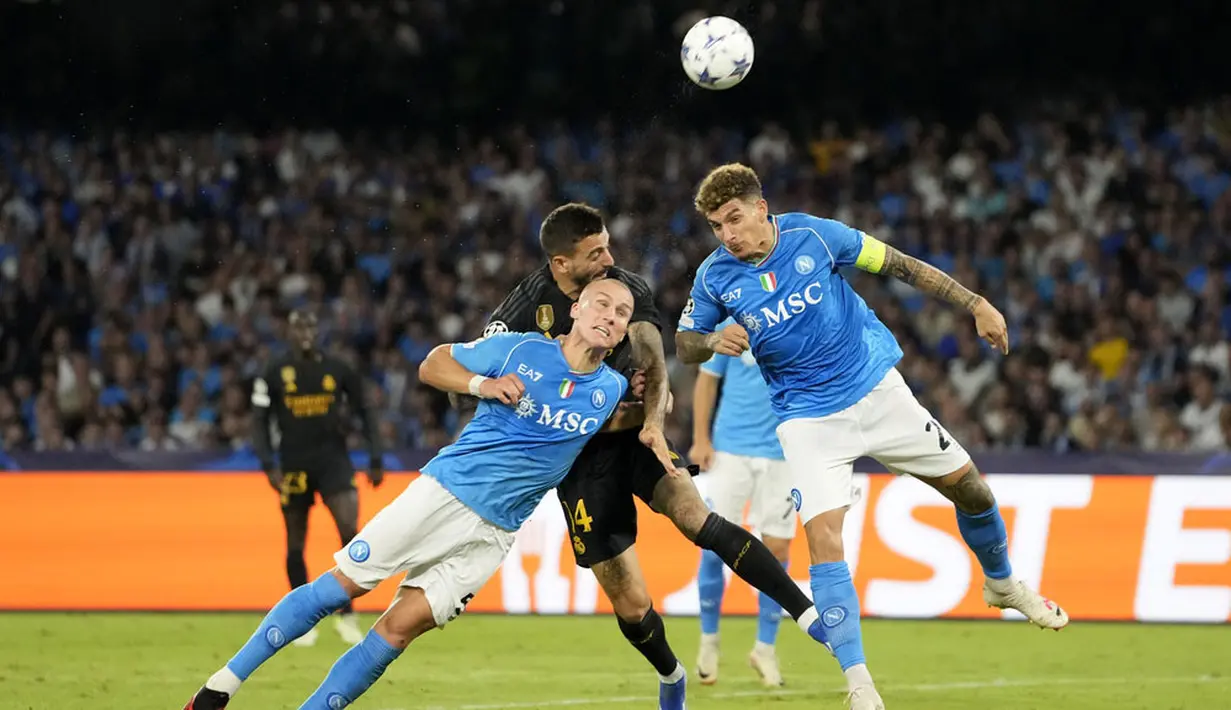 Pemain Napoli, Giovanni Di Lorenzo dan Leo Ostigard, duel udara dengan pemain Real Madrid, Joselu, pada laga Liga Champions di Stadion Diego Armando Maradona, Rabu (4/10/2023). (AP Photo/Alessandra Tarantino)