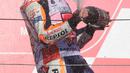 Pembalap Repsol Honda, Marc Marquez menyemprotkan sampanye saat berselebrasi di atas podium setelah memenangi balapan MotoGP Jepang 2018 di Twin Ring Motegi, Minggu (21/10). Marquez menang dengan catatan waktu 42 menit 36,438 detik . (Martin BUREAU / AFP)