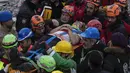 Raziye Kilinc dibawa melewati kerumunan dengan tandu setelah dia diselamatkan di bawah bangunan yang hancur di Iskenderun, Turki tenggara, Jumat (10/2/2023). Pasangan suami istri ditarik dari bawah puing-puing bangunan yang runtuh di Iskenderun setelah menghabiskan 109 jam terkubur di dalam celah kecil. (AP Photo/Petros Giannakouris)