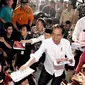 Presiden Joko Widodo atau Jokowi bersama Gubernur NTB Tuan Guru Bajang (TGB) Zainul Majdi membagikan buku saat mengunjungi korban gempa di lapangan Desa Madayin, Sambelia, Lombok Timur, NTB, Senin (30/7). (Agus Suparto/Indonesian Presidential Palace/AFP)