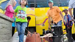 Para pemudik membawa barang bawaannya setibanya di Terminal Pulogadung, Jakarta, Jumat (1/8/14). (Liputan6.com/Faizal Fanani)