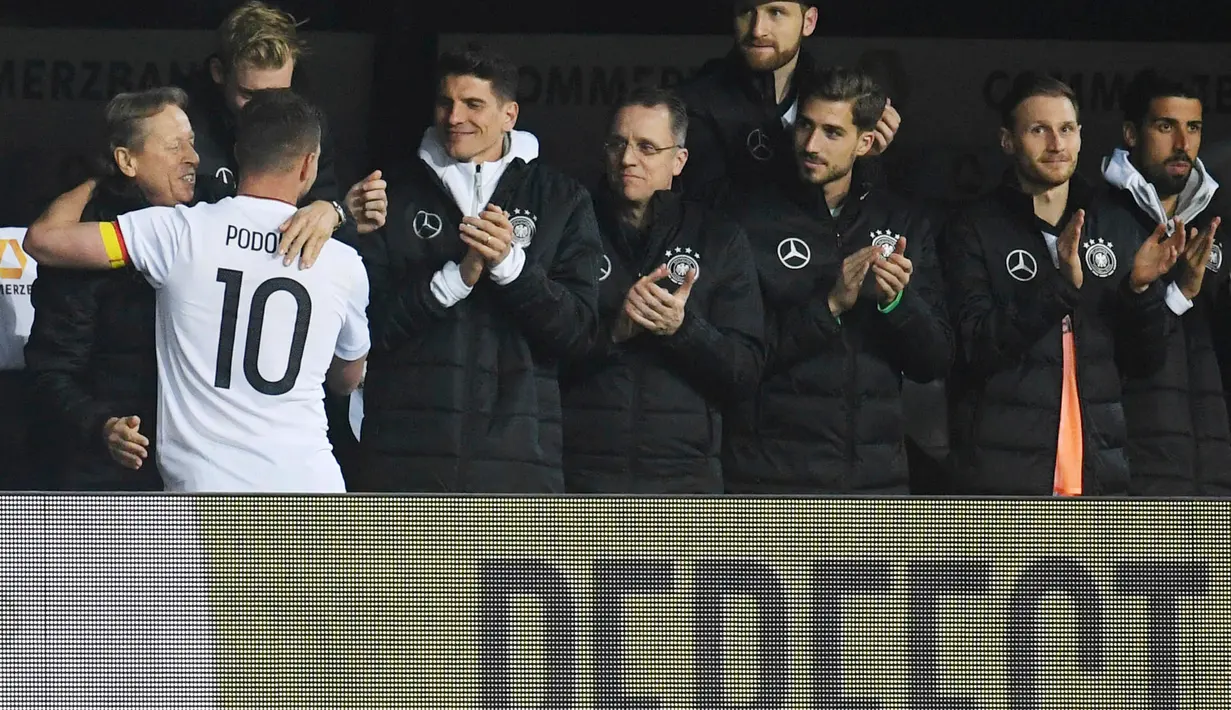 Lukas Podolski memeluk rekan satu timnya setelah pertandingan persahabatan antara Jerman dan Inggris di Dortmund, (23/3). Podolski mengumumkan gantung sepatu dari timnas Jerman pada 15 Oktober lalu. (Bernd Thissen/dpa via AP)