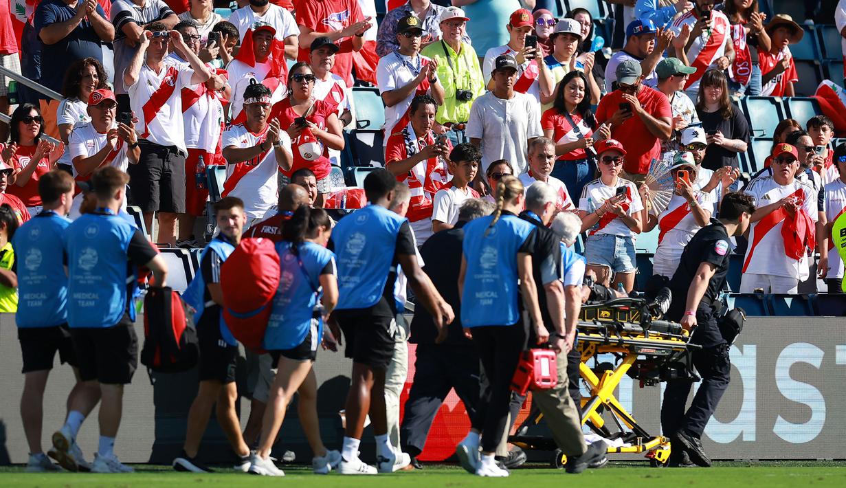 Fans Peru memberikan tepuk tangan saat asisten wasit Humberto Panjoj ditandu keluar lapangan setelah mengalami pingsan pada laga Grup A Copa America 2024 antara Peru melawan Kanada di Children's Mercy Park, Kansas City, Kansas, Selasa (25/06/2024) waktu setempat. (AFP/Getty Images/Hector Vivas)