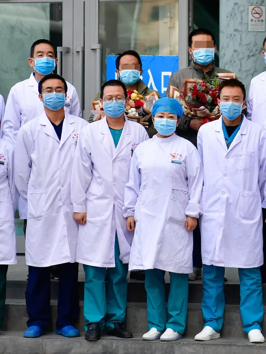 Dua pasien yang telah sembuh dari pneumonia akibat coronavirus baru (novel coronavirus pneumonia/NCP) berfoto bersama staf medis di Rumah Sakit Umum Rakyat Keempat Provinsi Qinghai di Xining, Provinsi Qinghai, China barat laut (21/2/2020). (Xinhua/Zhang Long)