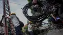Petugas PLN menggulung kabel dari sambungan listrik ilegal di Johar Baru, Jakarta, Rabu (25/3/2015). Kegiatan itu untuk mengurangi saluran listrik ilegal dan mencegah kebakaran.   (Liputan6.com/Faizal Fanani)