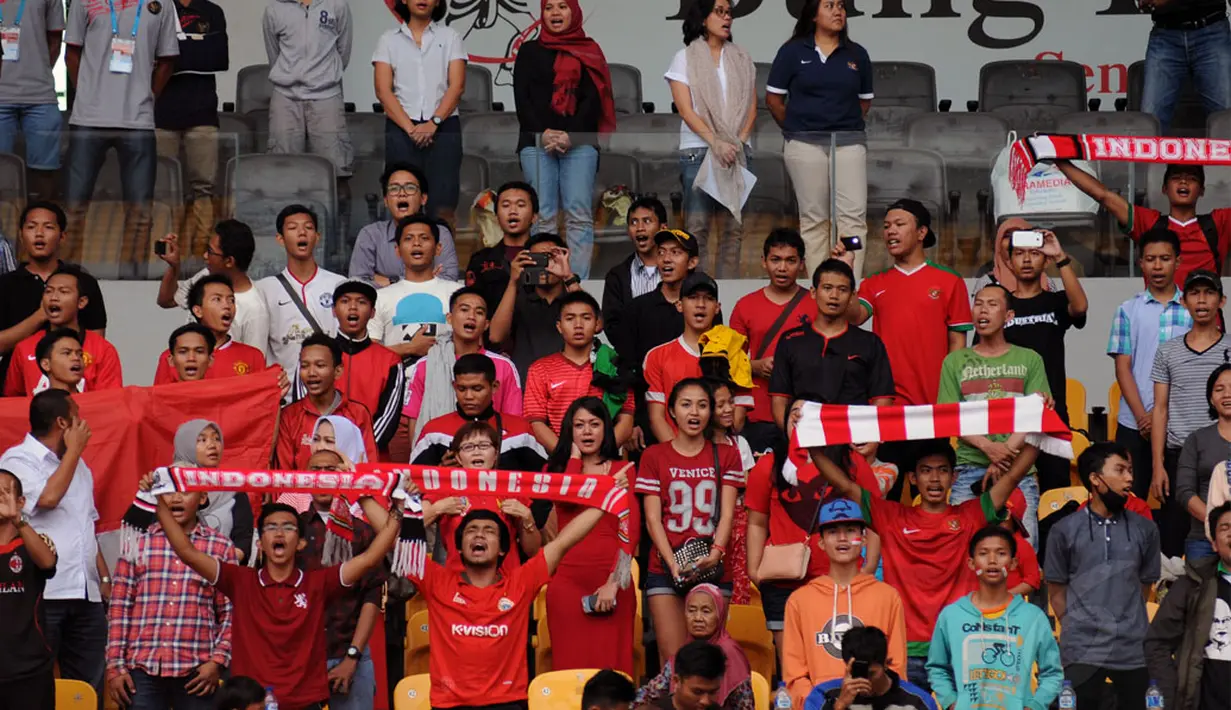 Sejumlah suporter timnas Indonesia memberikan yel yel semangat saat menyaksikan laga Garuda Muda vs timnas U-19 Singapura di Stadion GBK Jakarta, (8/12/2014). Indonesia unggul 1-0 atas Singapura. (Liputan6.com/Helmi Fithriansyah)