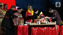 Ketua Umum PDI Perjuangan Megawati Soekarnoputri (kedua kanan) menyerahkan potongan tumpeng kepada Presiden Joko Widodo disaksikan Wakil Presiden Ma'ruf Amin (keempat kiri) saat pembukaan Rakernas I dan HUT ke-47 PDIP di JIEXPO Kemayoran, Jakarta, Jumat (10/1/2020). (Liputan6.com/Johan Tallo)