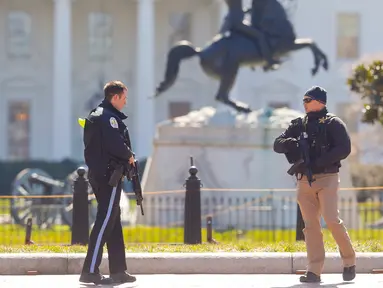 Petugas bersenjata berjaga di Lafayette Park, seberang Gedung Putih, Washington, Amerika Serikat, Sabtu (3/3). Petugas menutup akses pejalan kaki di kawasan itu setelah seorang pria bunuh diri di depan Gedung Putih. (AP Photo/Pablo Martinez Monsivais)