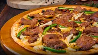 Saat disantap, sensasi unik sekaligus pizza rendang terasa di gigitan pertama, tertarik coba? (Foto: Dok. Domino's Pizza) 
