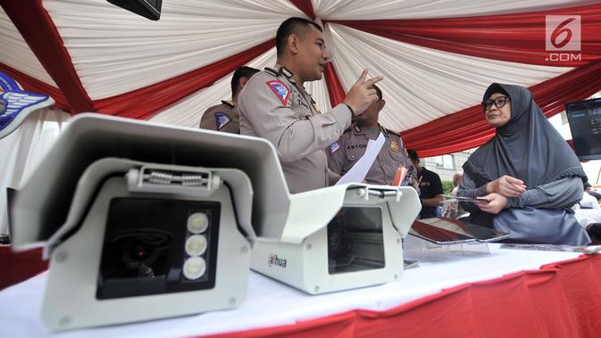Polisi menyosialisasikan sistem Electronic Traffic Law Enforcement (ETLE) kepada warga di kawasan Bundaran HI, Jakarta, Minggu (25/11). Sistem ETLE menggunakan kamera berteknologi canggih. (Merdeka.com/Iqbal Nugroho)