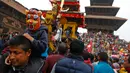 Seorang anak mengenakan topeng duduk di pundak ayahnya saat mengikuti festival Bisket Jatra di Bhaktapur, Nepal (10/4). Festival ini diadakan untuk menandai Tahun Baru Nepal.  (AP Photo/Niranjan Shrestha)
