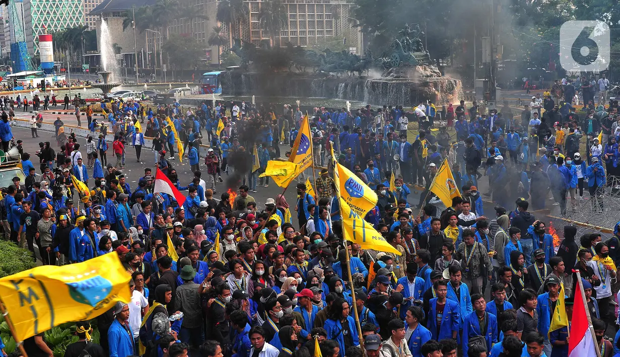 Dalam kerumunan massa terlihat asap hitam bekas ban terbakar saat aksi unjuk rasa atau demo BBM naik di kawasan Patung Kuda, Jakarta, Senin (5/9/2022). Ketegangan sempat terjadi antara massa dengan aparat. Lempar botol dan sejumlah benda dilakukan mahasiswa ke arah aparat. (Liputan6.com/Angga Yuniar)