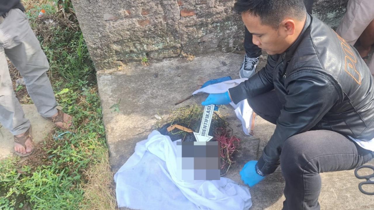 Anggota Polsek Garut Kota beserta Unit Inafis Polres Garut tengah melakukan olah kejadian perkara penemuan bayi mungil laki-laki di jalan Gang Pesawahan, Garut Kota, Kabupaten Garut. (Liputan6.com/Jayadi Supriadin)