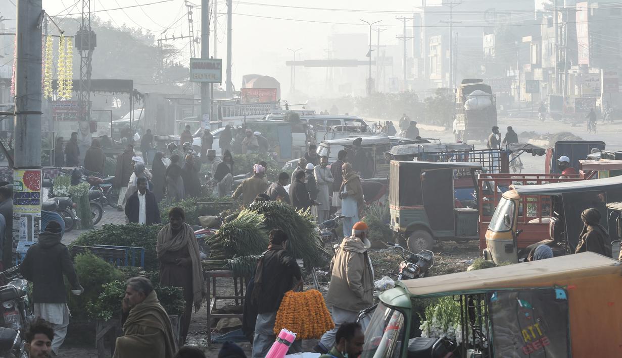 Para pedagang bekerja di pasar bunga di tengah kondisi kabut asap di Lahore, Pakistan (23/11/2021). Kondisi kabut asap yang memburuk membuat Lembaga pendidikan, kantor swasta tutup selama tiga hari seminggu di Lahore. (AFP/Arif Ali)