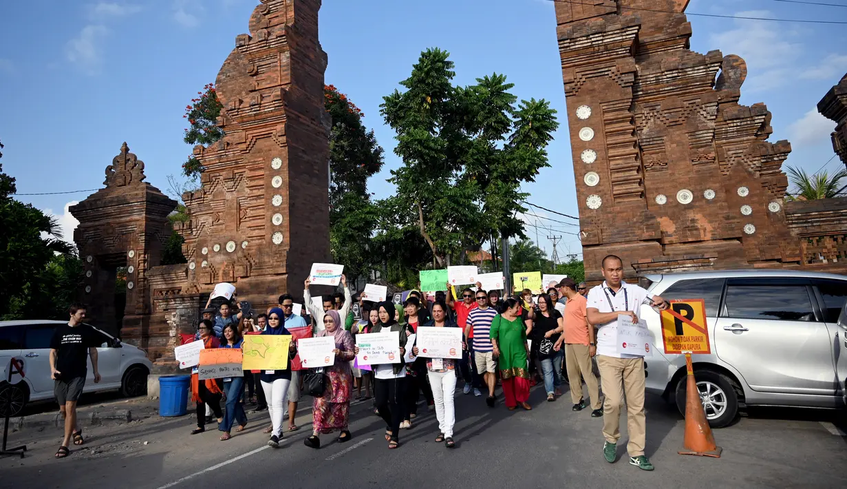 Massa mengangkat plakat saat kampanye perubahan iklim global di Pantai Sanur, Bali, Jumat (20/9/2019). Aksi ini dijuluki sebagai gerakan Jumat untuk Masa Depan. (SONNY TUMBELAKA/AFP)