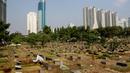 Pekerja tengah membersihkan area makam di TPU Karet Bivak, Jakarta, Kamis (2/10/14). (Liputan6.Com/Faizal Fanani)