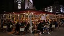 Orang-orang menikmati minuman di teras restoran di Lille, Prancis, Jumat (16/10/2020). Prancis mengerahkan 12.000 polisi untuk memberlakukan jam malam baru mulai Jumat malam hingga bulan depan untuk memperlambat penyebaran COVID-19. (AP Photo/Michel Spingler)