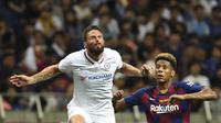 Striker Chelsea, Olivier Giroud berebut bola udara dengan bek Barcelona Jean-Clair Todibo  selama pertandingan laga perdana pramusim di Saitama Stadium 2002, Saitama, Selasa (23/7/2019). Chelsea menang tipis 2-1 atas Barcelona. (AFP Photo/Toshifumi Kitamura)